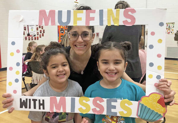 Mother and 2 daughters pose with Muffins with Misses sign