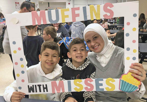 Mother and two sons pose with Muffins with Misses sign