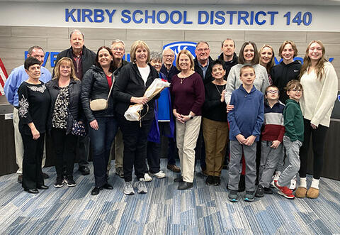 Proud family and friends gathered for group photo in district board room