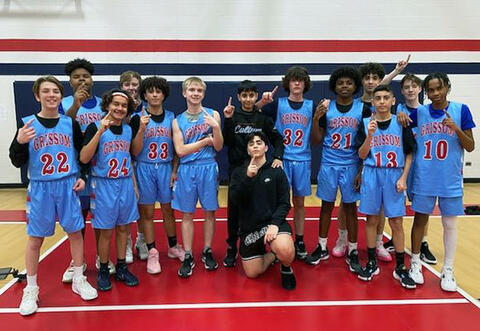Grissom's 8th Grade boys' basketball team proudly pose with one finger up after winning first place in conference