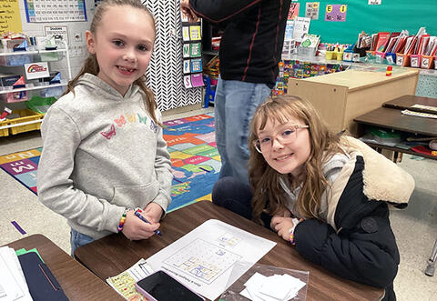 Two students pose proudly during school math night