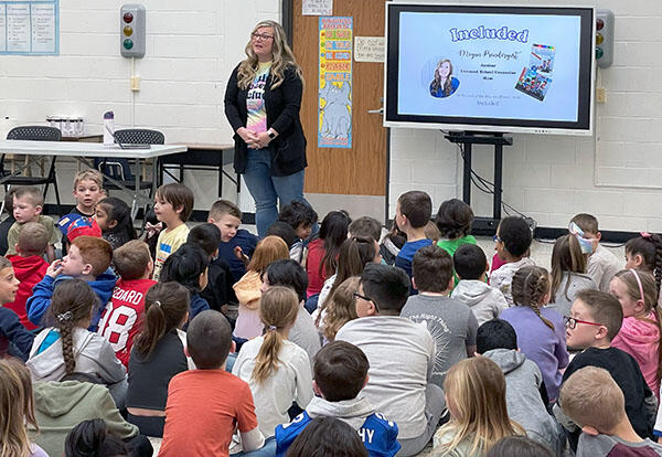 Student sitting and listening to author that visited school